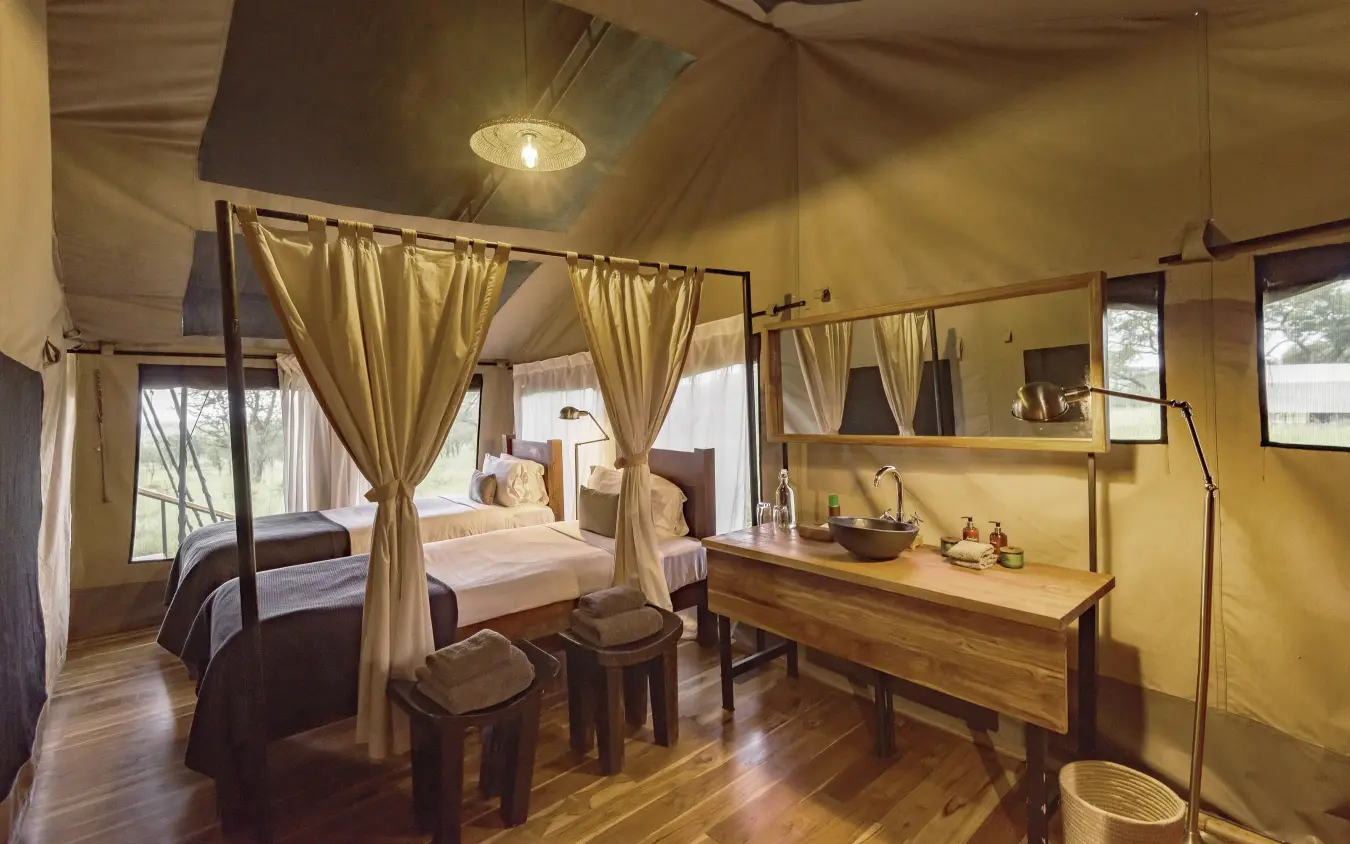 Luxury safari bedroom with four-poster bed and canvas walls, Dunia Camp, Serengeti National Park, Tanzania