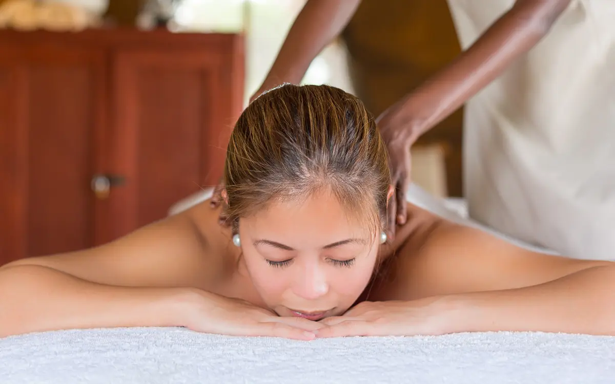 Woman receiving spa massage treatment on table in indoor wellness facility, Elephant Bedroom Camp, Samburu Reserve, Kenya