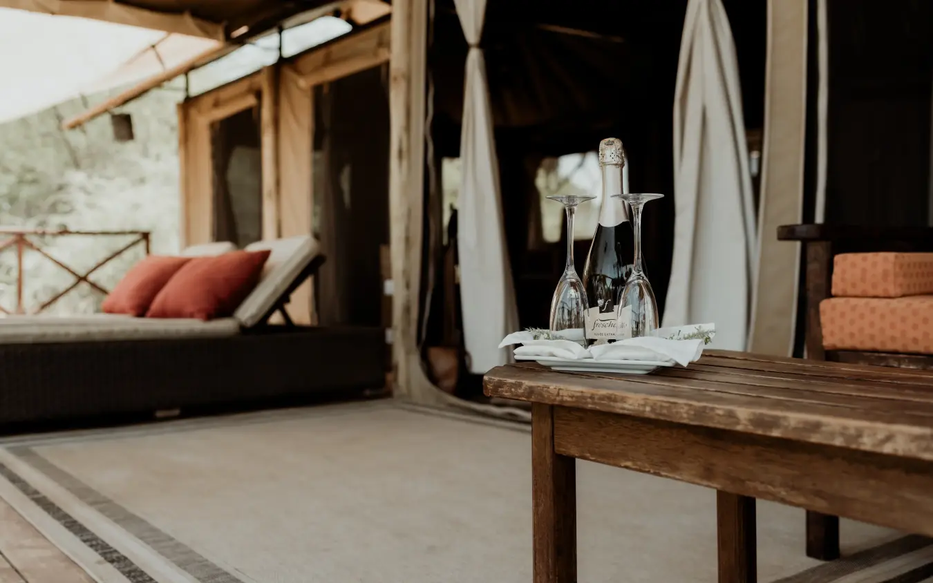 Champagne service on wooden table overlooking safari lodge terrace, Elephant Bedroom Camp, Samburu Reserve, Kenya