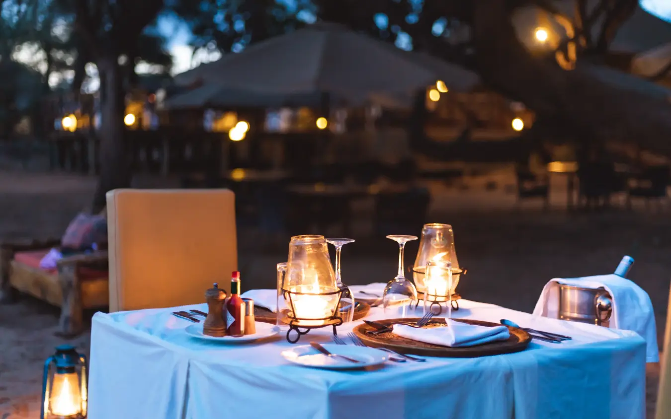 Outdoor dinner table set for two at dusk with lantern lighting, Elephant Bedroom Camp, Samburu Reserve, Kenya