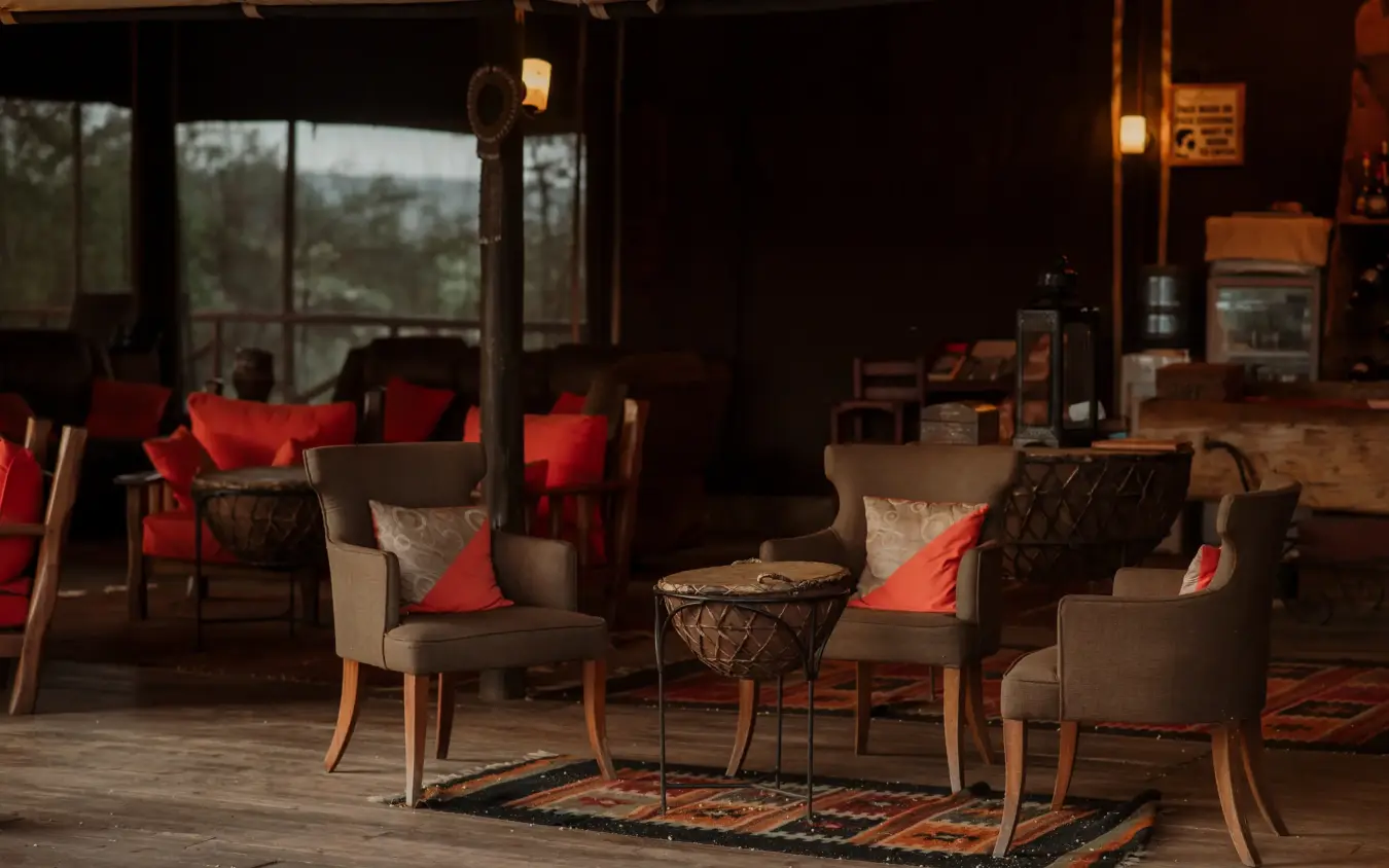 Lounge area with upholstered seating and red cushions overlooking savanna landscape, Elephant Bedroom Camp, Samburu Reserve, Kenya