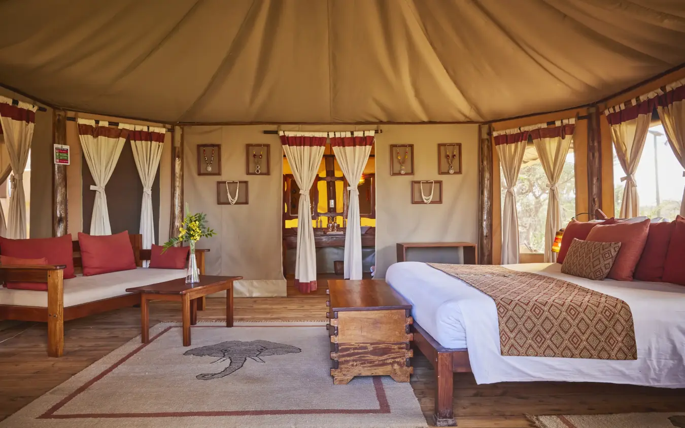 Luxury safari tent interior with bed, seating area and canvas furnishings, Elephant Bedroom Camp, Samburu Reserve, Kenya