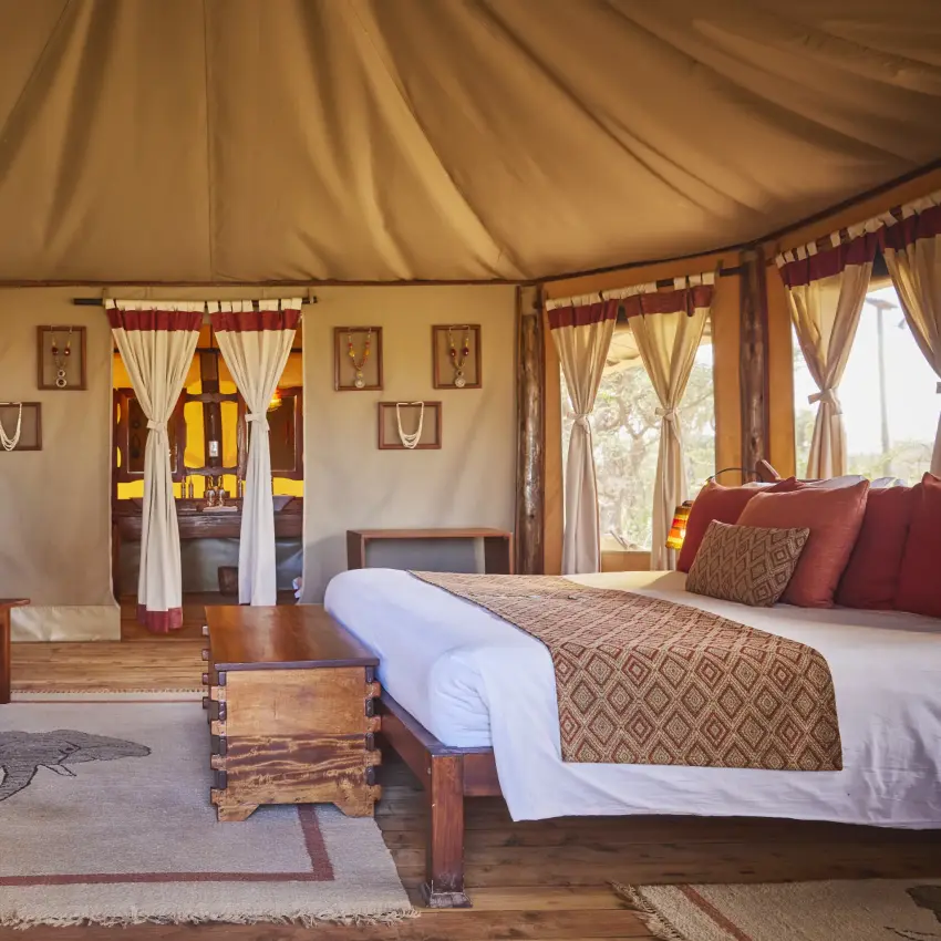 Luxury safari tent interior with bed, seating area and canvas furnishings, Elephant Bedroom Camp, Samburu Reserve, Kenya