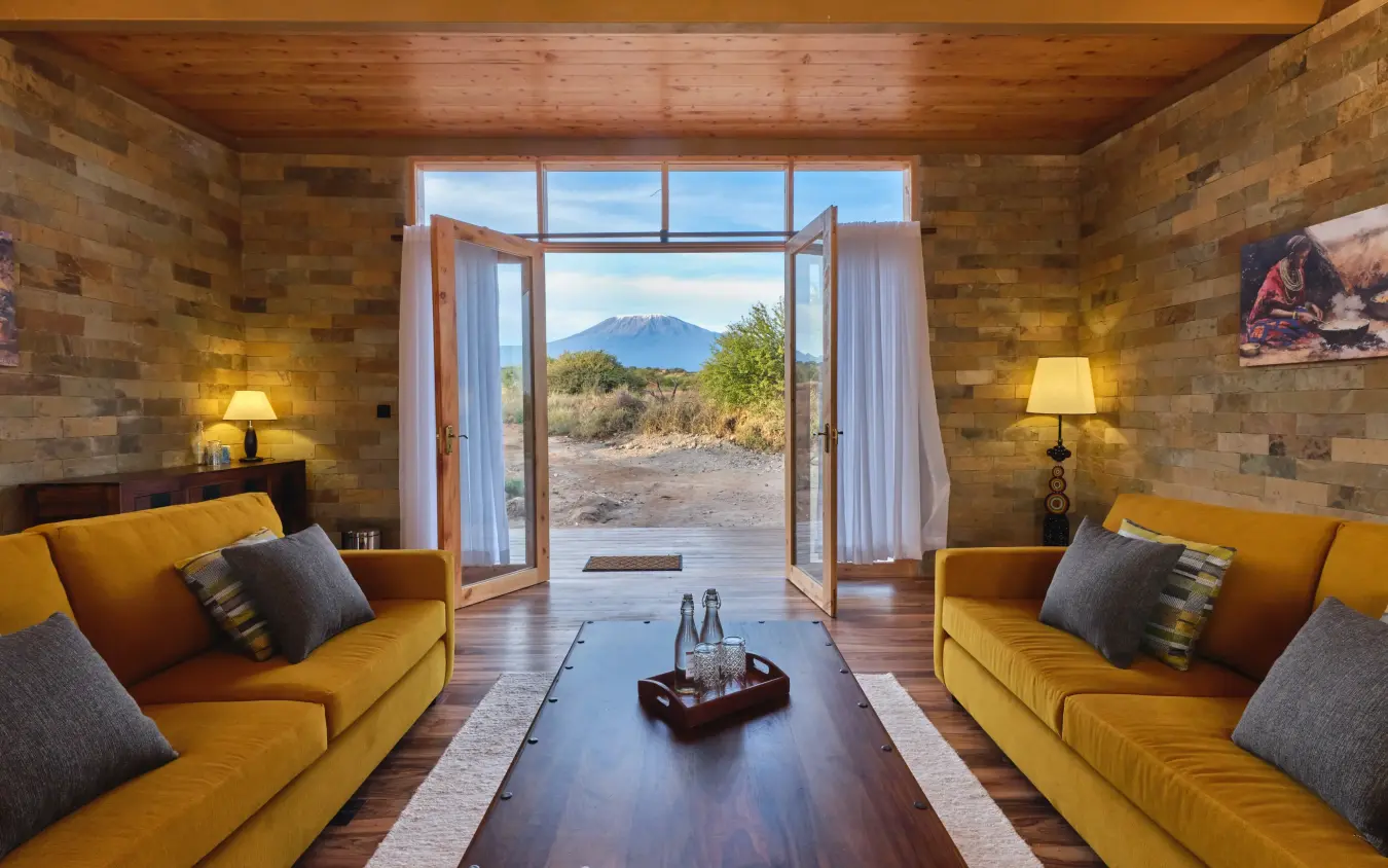 Luxury lodge interior with volcano view through open glass doors, Elephant Gorge Camp, Amboseli and Chyulu Hills, Kenya