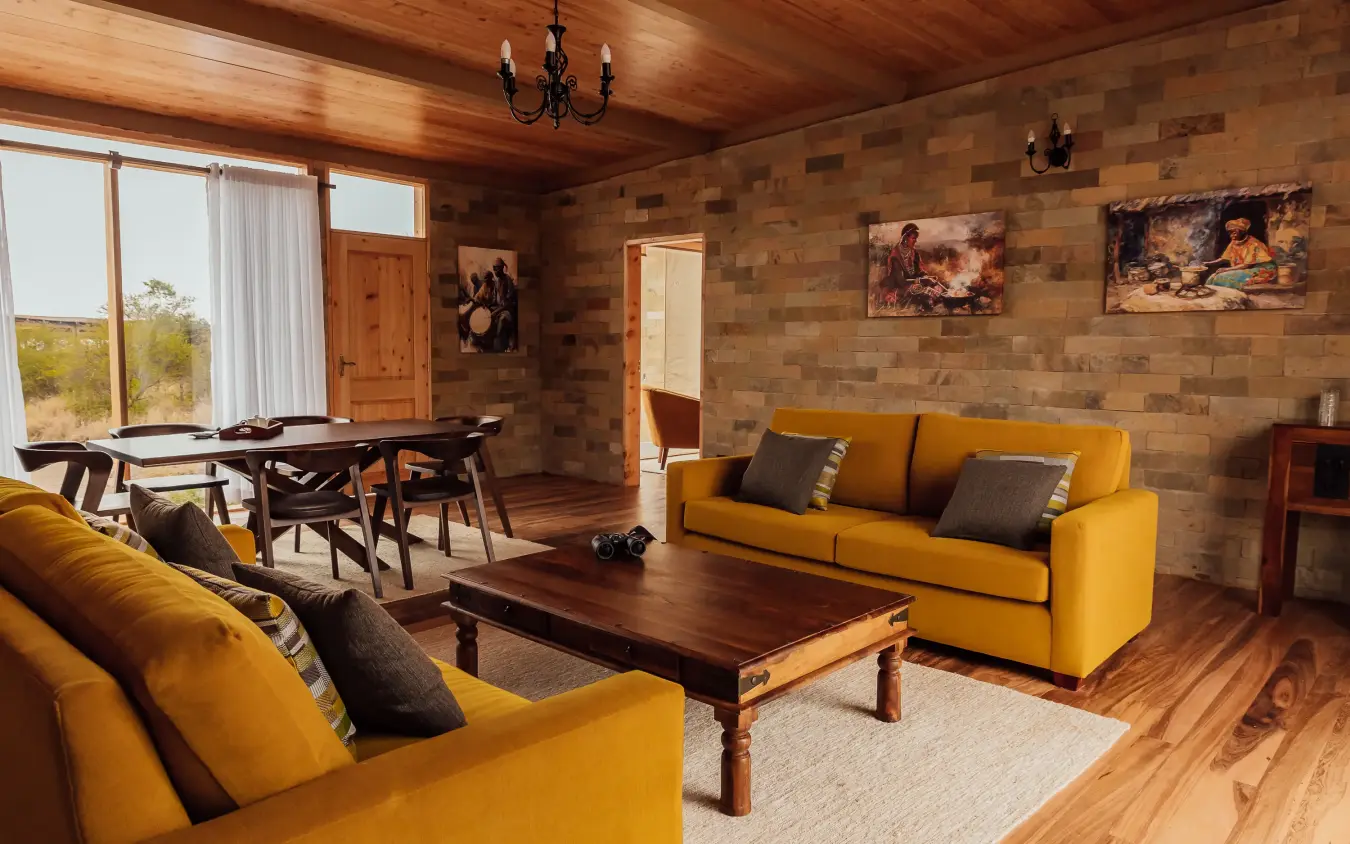 Luxury lodge interior with yellow sofas and wooden furnishings, Elephant Gorge Camp, Amboseli and Chyulu Hills, Kenya