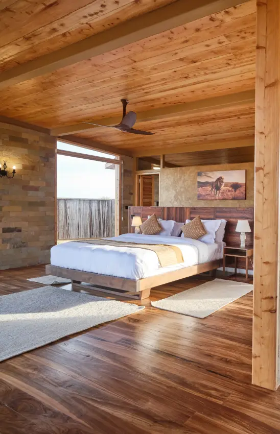 Wooden bedroom interior with ceiling fan and large windows overlooking landscape, Elephant Gorge Camp, Amboseli and Chyulu Hills, Kenya