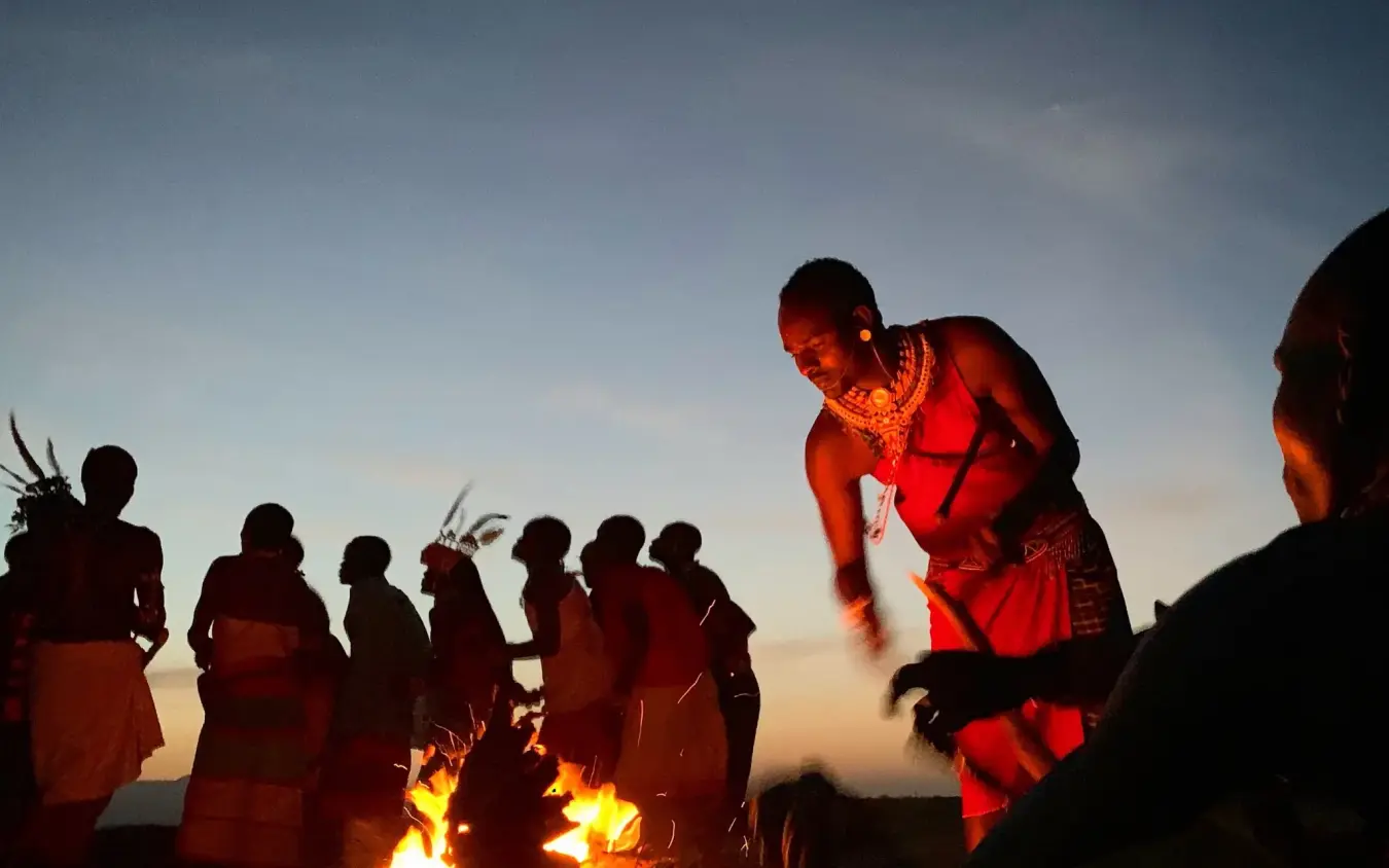 Maasai warriors gathered around evening campfire under moonlight, Elephant Watch Camp, Samburu Reserve, Kenya