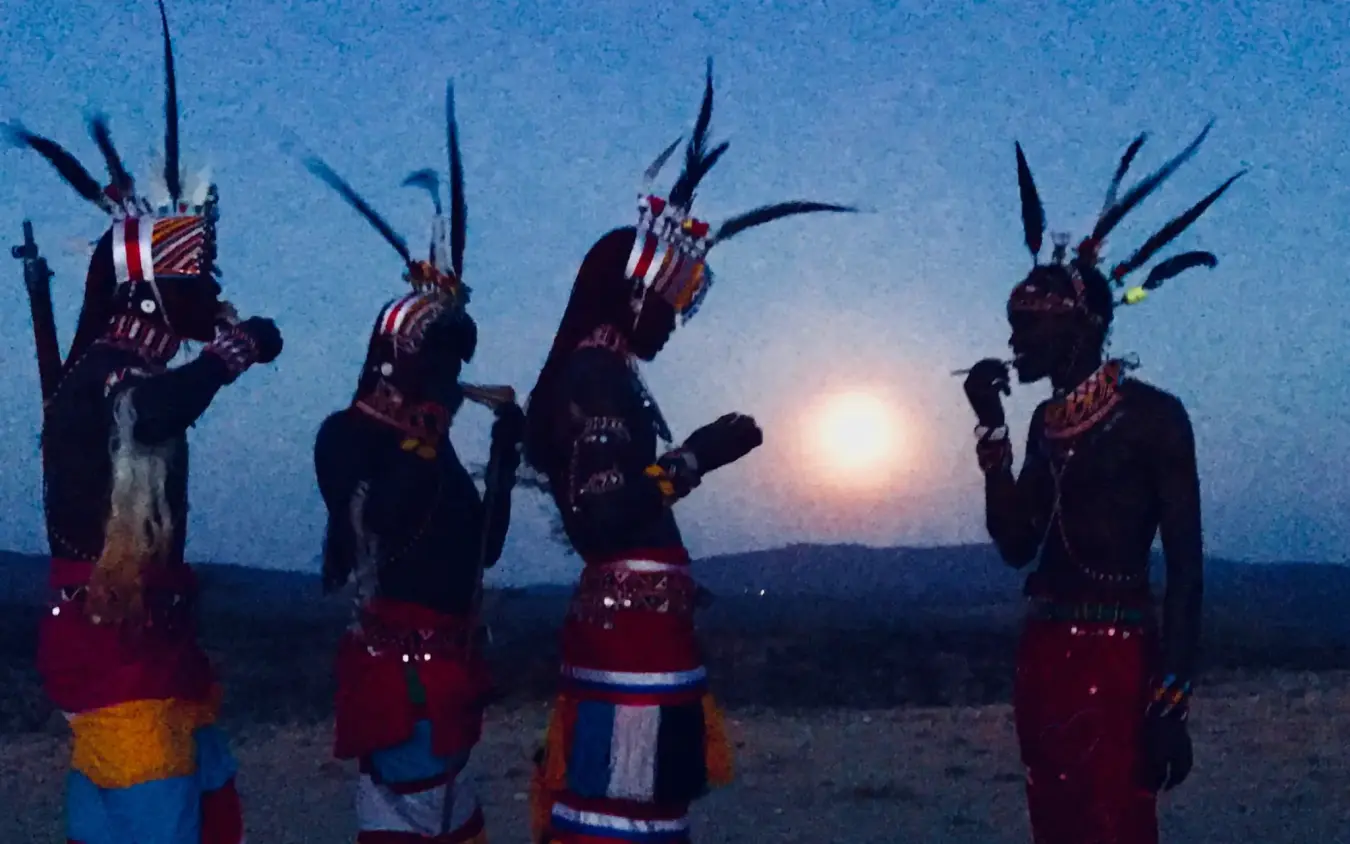 Indigenous warriors in traditional dress at dusk, Elephant Watch Camp, Samburu Reserve, Kenya