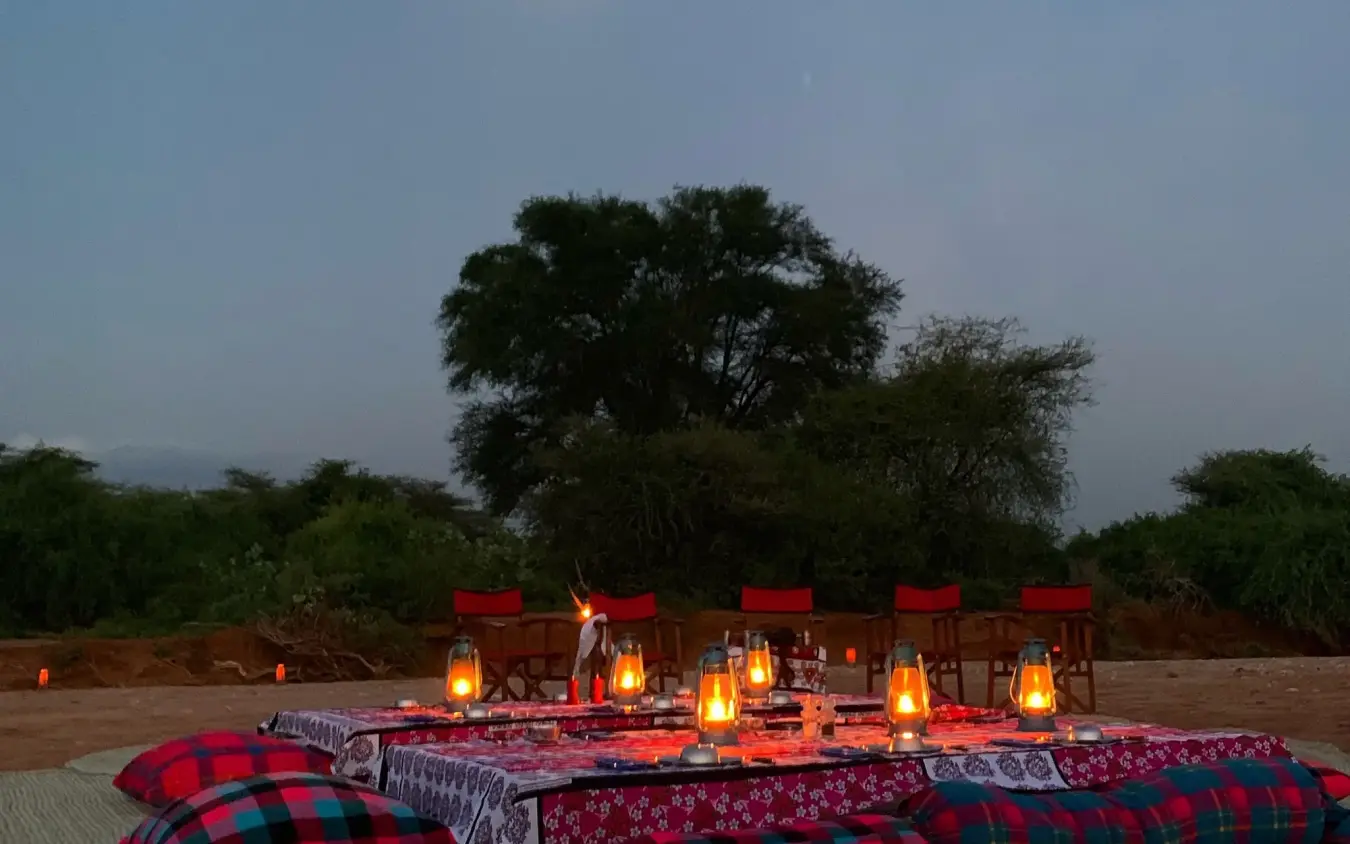 Open-air dining setup under moonlight with lanterns, Elephant Watch Camp, Samburu Reserve, Kenya