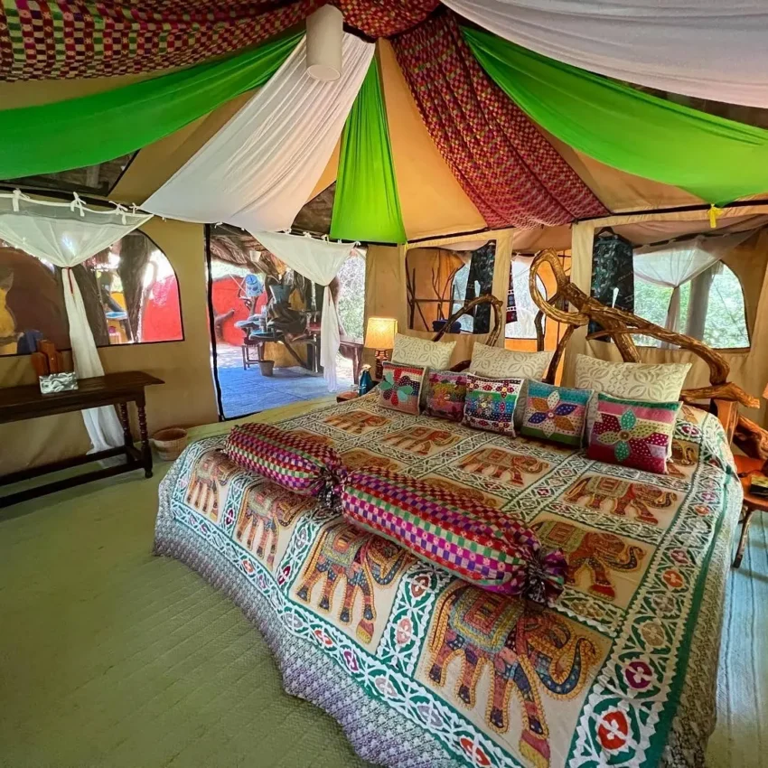 Spacious canvas tent interior with colorful patterned bedding and furnishings, Elephant Watch Camp, Samburu Reserve, Kenya