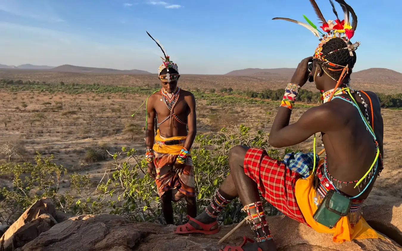Indigenous warriors in traditional dress on savanna landscape, Elephant Watch Camp, Samburu Reserve, Kenya