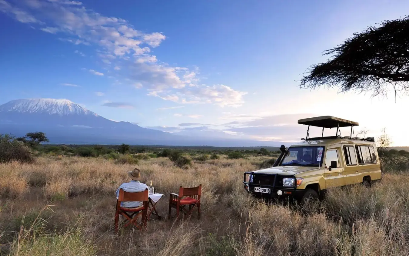 Safari vehicle with guests watching Mount Kilimanjaro at sunset, Elerai, Amboseli and Chyulu Hills, Kenya