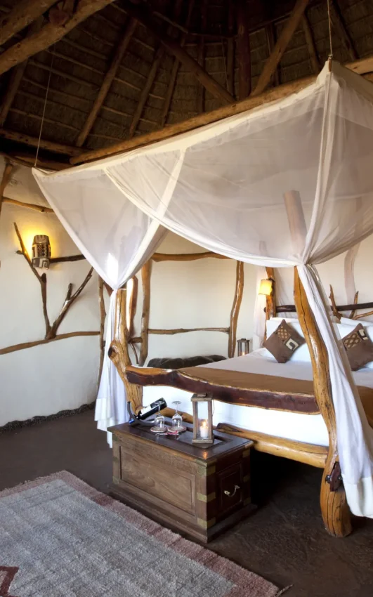 Luxury safari bedroom with four poster canopy bed and natural wood frame, Elerai, Amboseli and Chyulu Hills, Kenya