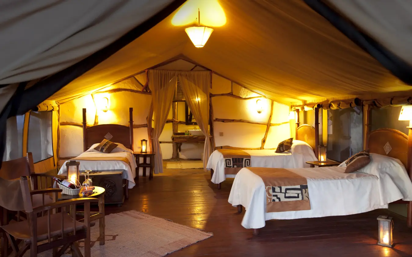 Spacious safari tent bedroom with multiple beds and warm lighting, Elerai, Amboseli and Chyulu Hills, Kenya