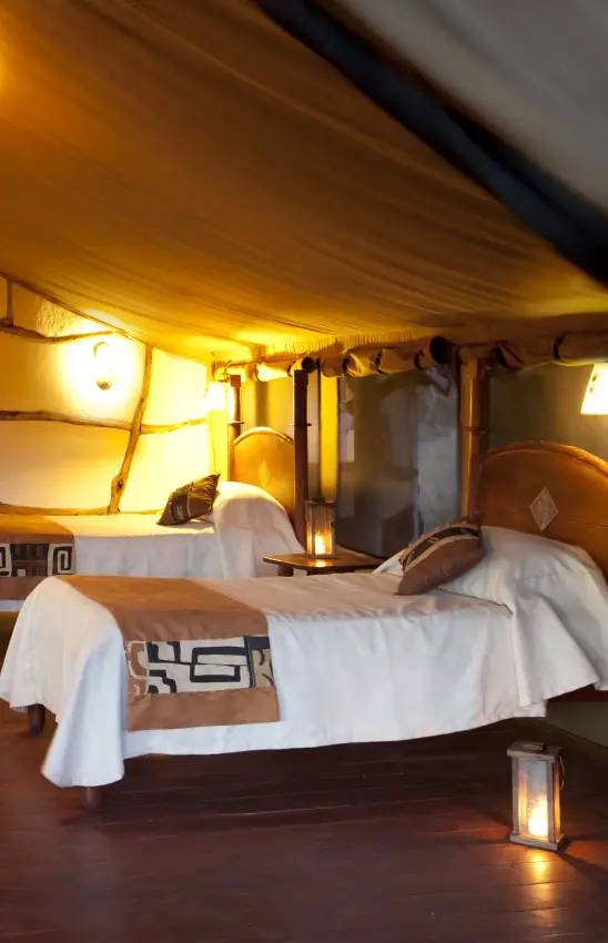 Spacious safari tent bedroom with multiple beds and warm lighting, Elerai, Amboseli and Chyulu Hills, Kenya