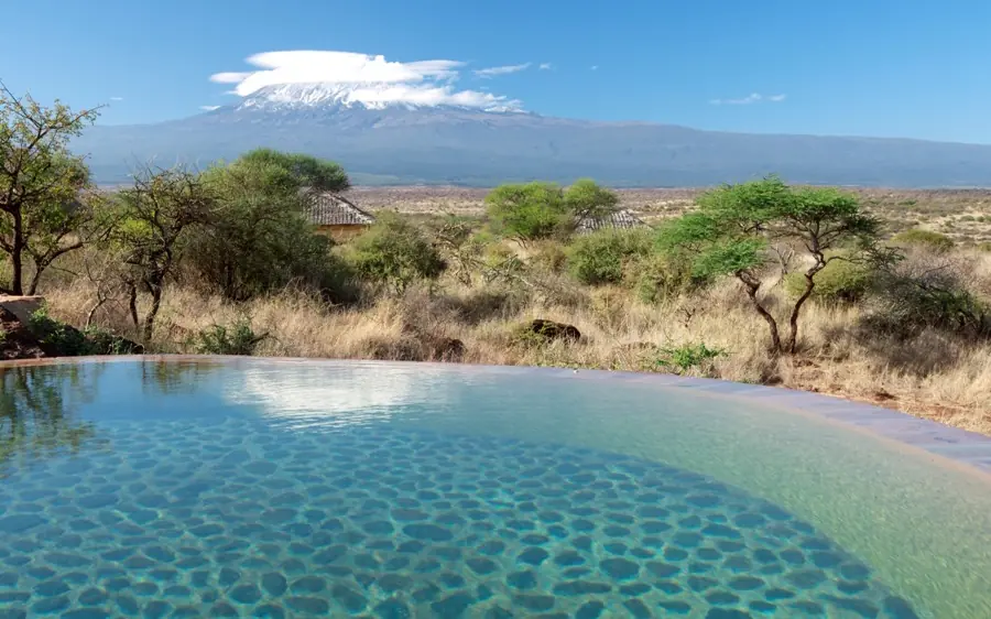 Infinity pool overlooking savanna with Mount Kilimanjaro, Elerai, Amboseli and Chyulu Hills, Kenya