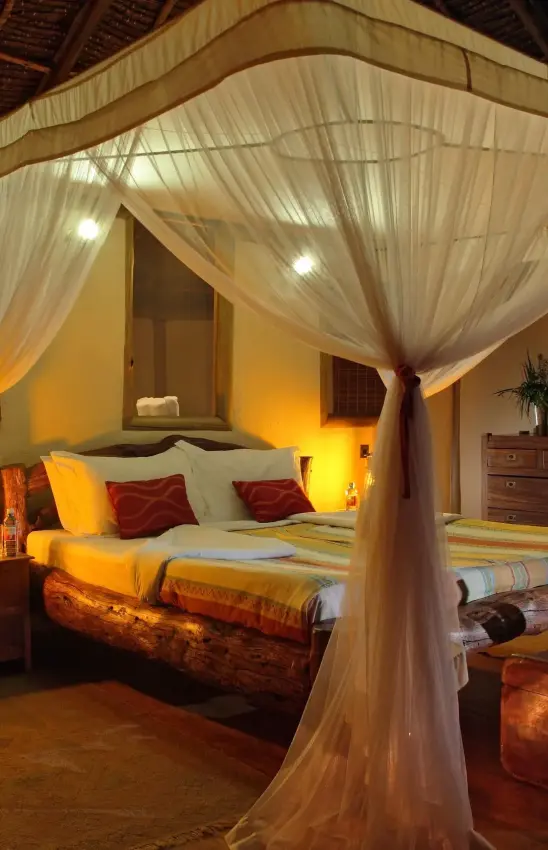 Spacious bedroom with four-poster bed and warm lighting, Tortilis Camp, Amboseli and Chyulu Hills, Kenya
