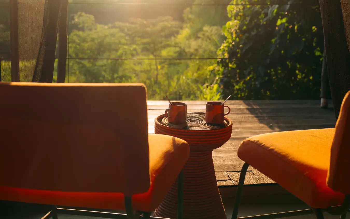 Sunrise view from lounge chairs overlooking savanna landscape, Emboo Camp, Maasai Mara, Kenya