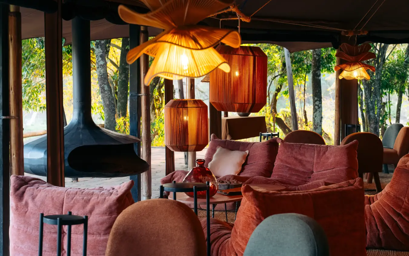 Open-air lounge with hanging lamps and earth-toned seating, Emboo Camp, Maasai Mara, Kenya