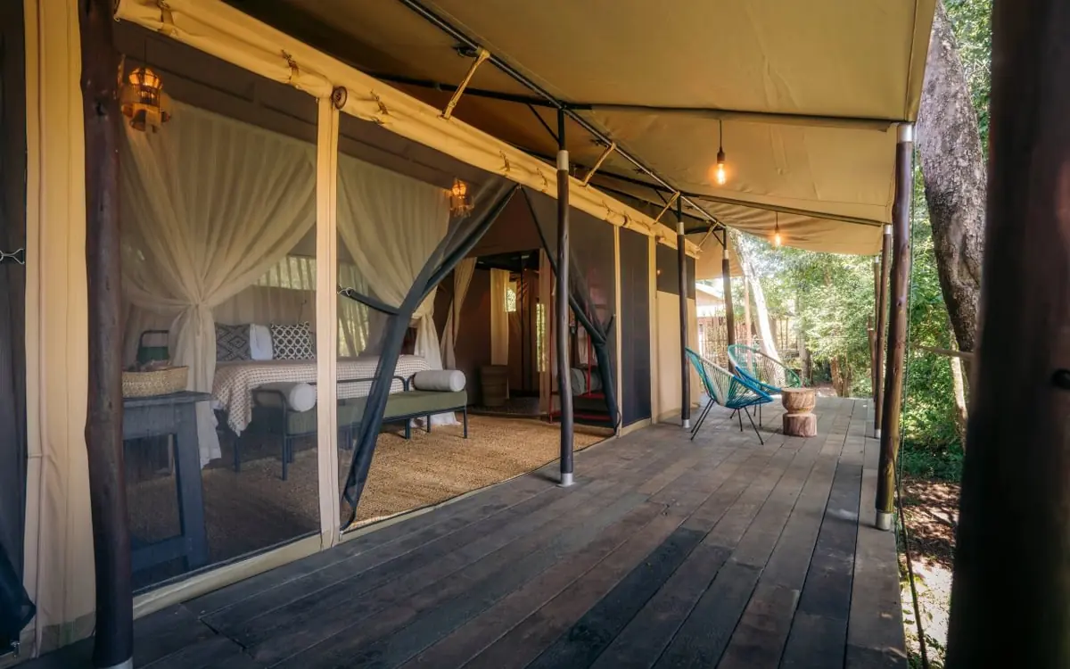 Luxury canvas bedroom tent with deck and forest views, Emboo Camp, Maasai Mara, Kenya