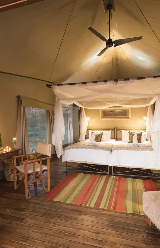 Spacious safari tent bedroom with four-poster bed and seating, Encounter by Ongava, Etosha National Park, Namibia
