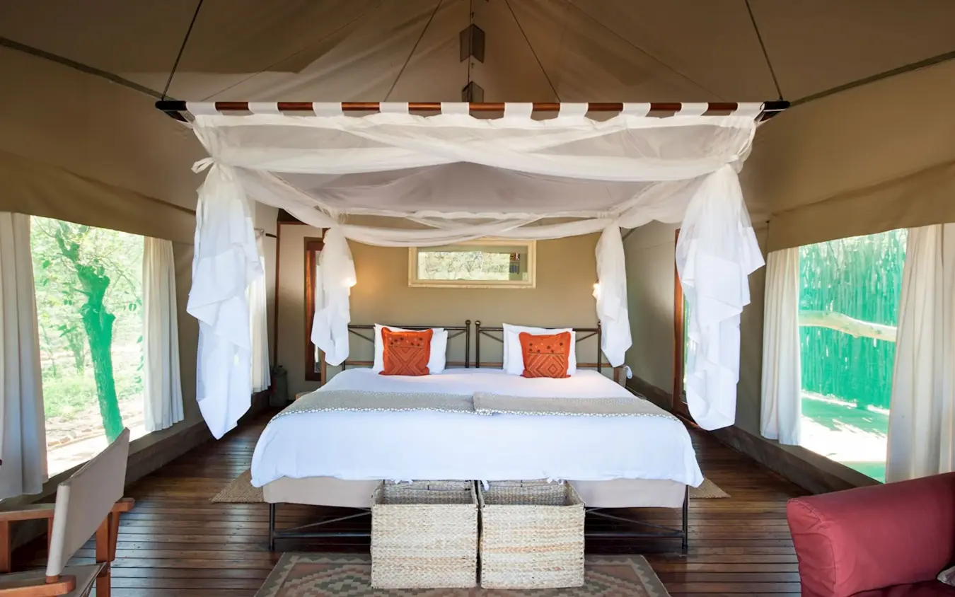Spacious canvas bedroom with four-poster bed and natural light, Encounter by Ongava, Etosha National Park, Namibia