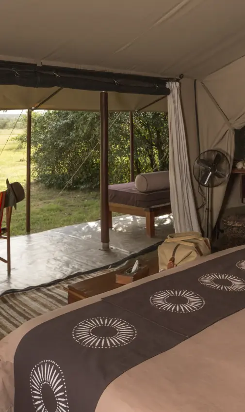 Safari tent bedroom with open views of grassland landscape, Encounter Mara Camp, Maasai Mara, Kenya