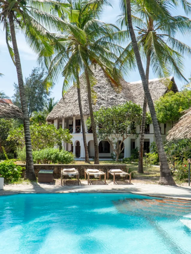 Swimming pool with thatched structures and palm trees at tropical resort, Enkare Bofa, Kilifi, Kenya