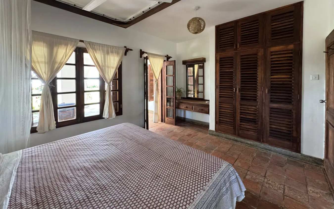 Spacious bedroom with wooden shutters and terra cotta floor tiles, Enkare Bofa, Kilifi, Kenya