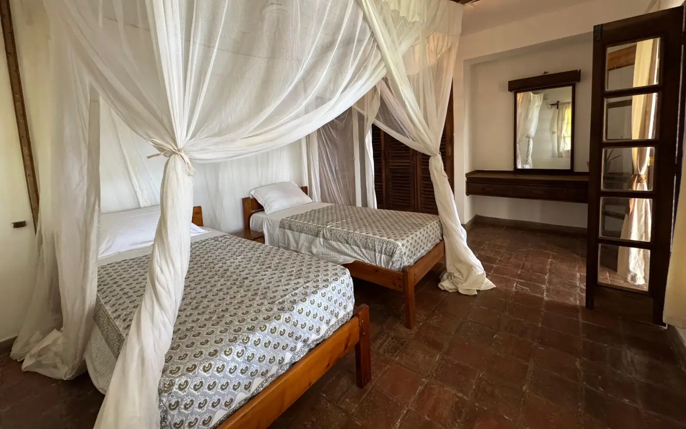 Canopy beds with white drapes in spacious bedroom suite, Enkare Bofa, Kilifi, Kenya