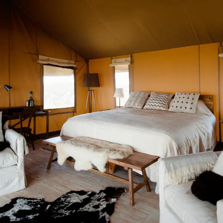Safari tent bedroom with queen bed and seating areas, Entamanu Camp, Ngorongoro Crater, Tanzania