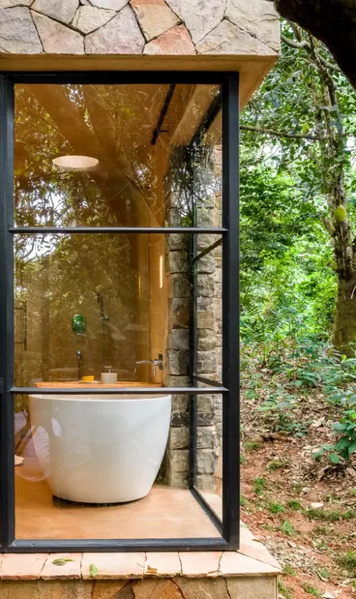 Modern white bathtub in forest lodge window view, Entebbe Forest Lodge, Entebbe and Kampala, Uganda