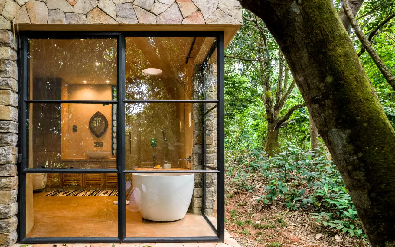 Modern white bathtub in forest lodge window view, Entebbe Forest Lodge, Entebbe and Kampala, Uganda