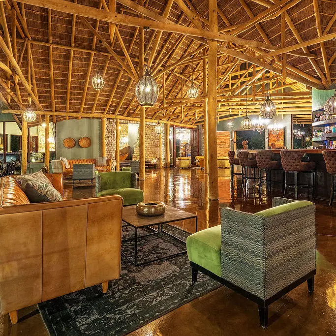 Interior lounge with wooden beams and leather seating, Etosha Oberland Lodge, Etosha National Park, Namibia