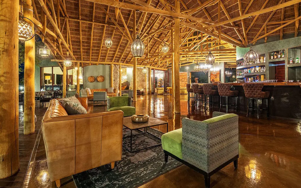Interior lounge with wooden beams and leather seating, Etosha Oberland Lodge, Etosha National Park, Namibia