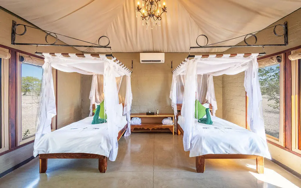 Twin canopy beds in spacious safari lodge bedroom, Etosha Oberland Lodge, Etosha National Park, Namibia
