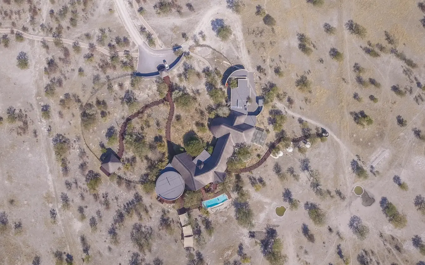 Aerial view of safari lodge surrounded by sparse woodland, Etosha Oberland Lodge, Etosha National Park, Namibia