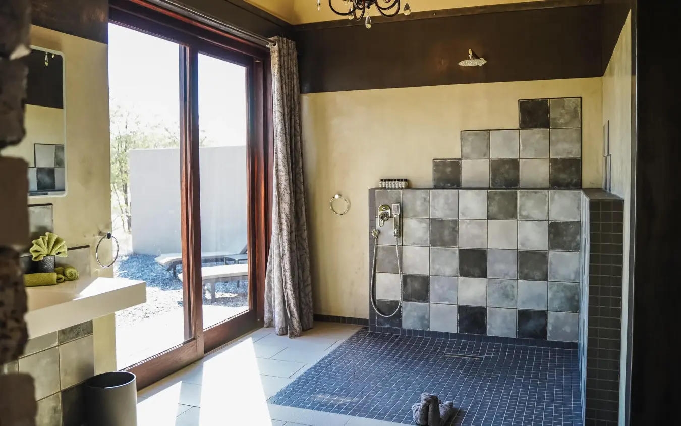 Modern bathroom with walk-in shower and desert view doors, Etosha Oberland Lodge, Etosha National Park, Namibia