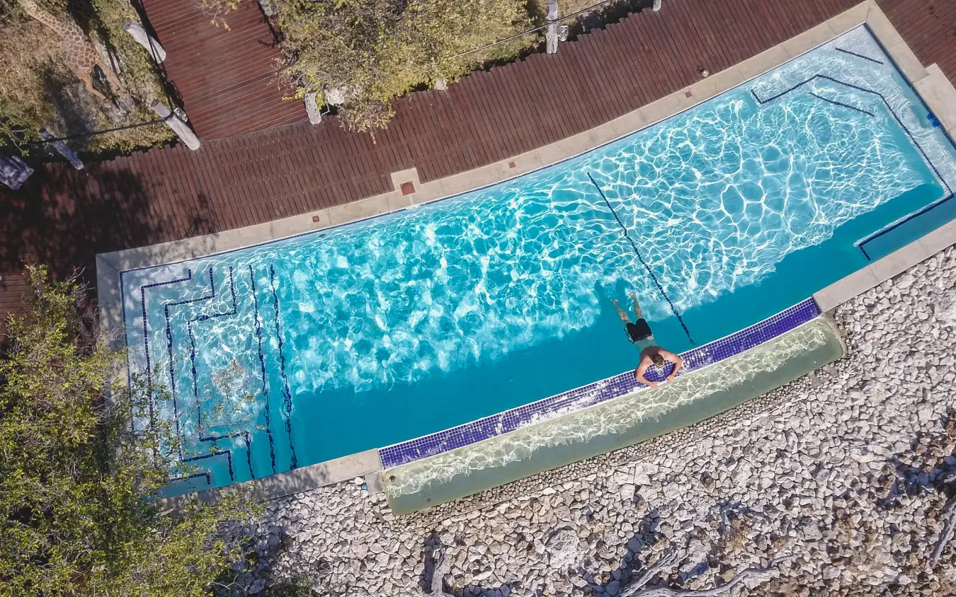 Rectangular swimming pool with turquoise water and lounge area, Etosha Oberland Lodge, Etosha National Park, Namibia