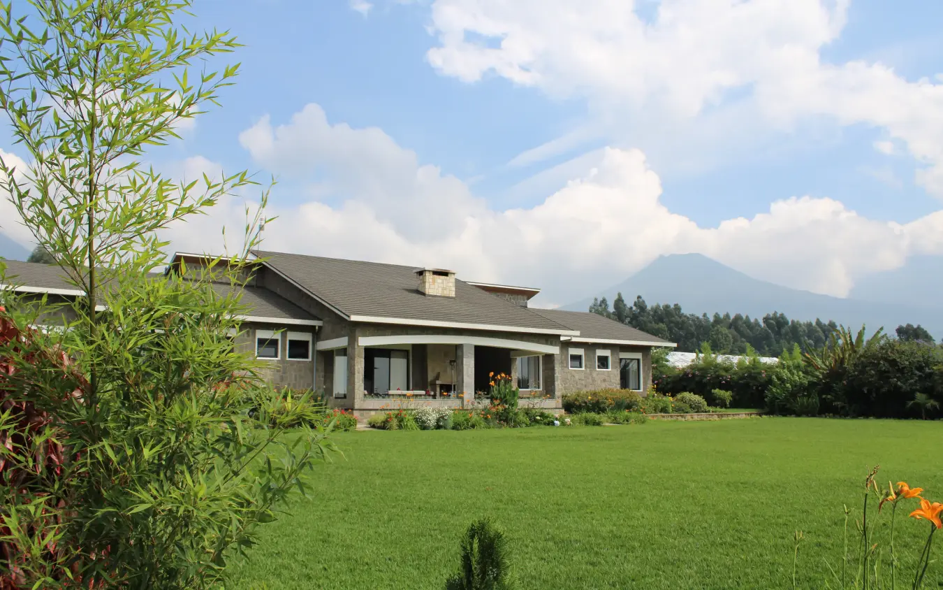 Contemporary farmhouse with manicured lawn and mountain backdrop, Farmhouse Rwanda, Volcanoes National Park, Rwanda