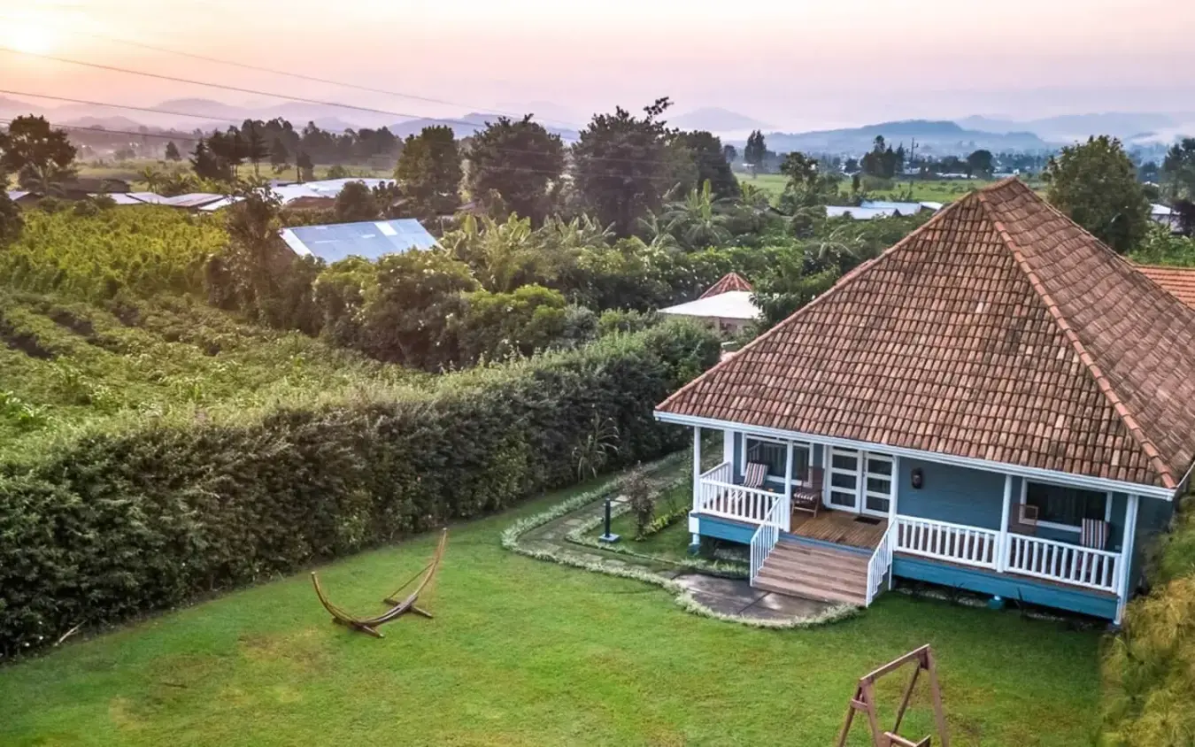 Colonial-style lodge with pitched roof overlooking green valleys, Five Volcanoes, Volcanoes National Park, Rwanda
