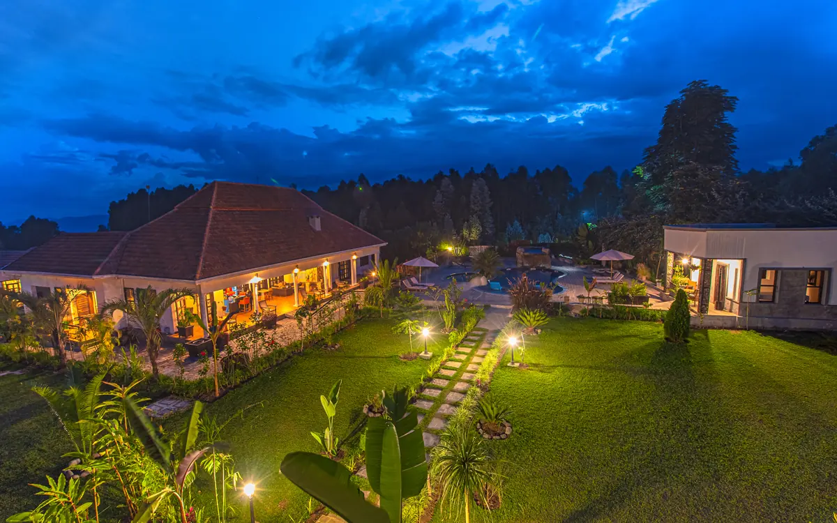 Illuminated lodge buildings and manicured grounds at dusk, Five Volcanoes, Volcanoes National Park, Rwanda