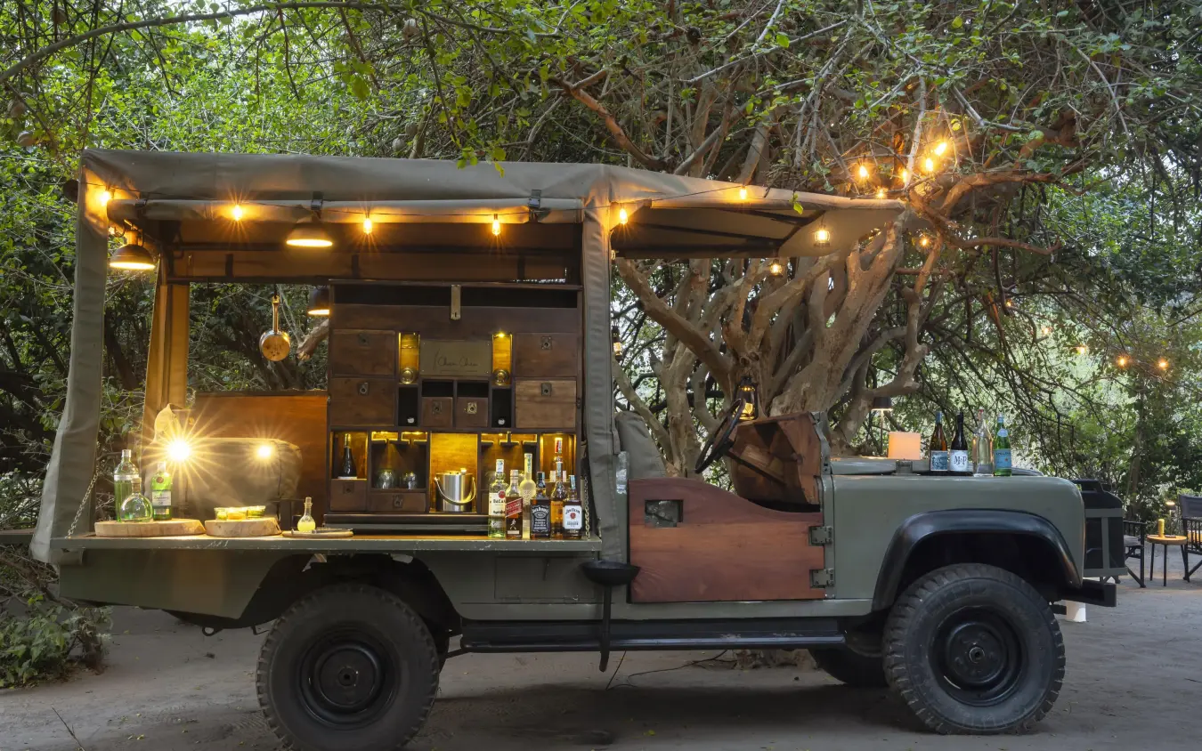 Mobile bar truck with illuminated shelving and bottles displayed, Forest Chem Chem, Lake Manyara, Tanzania