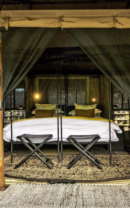 Luxury safari tent bedroom with canopy bed and deck entrance, Forest Chem Chem, Lake Manyara, Tanzania