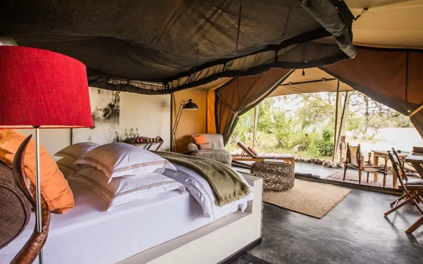 Safari tent bedroom with bed, lamp, and outdoor views, Forest Chem Chem, Lake Manyara, Tanzania