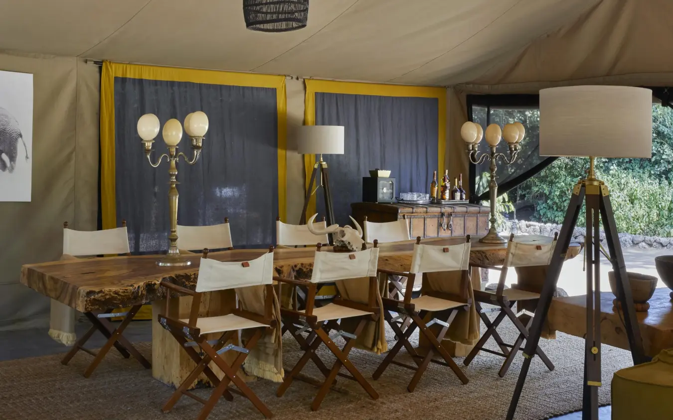 Luxury tent dining area with canvas walls and wooden furniture, Forest Chem Chem, Lake Manyara, Tanzania