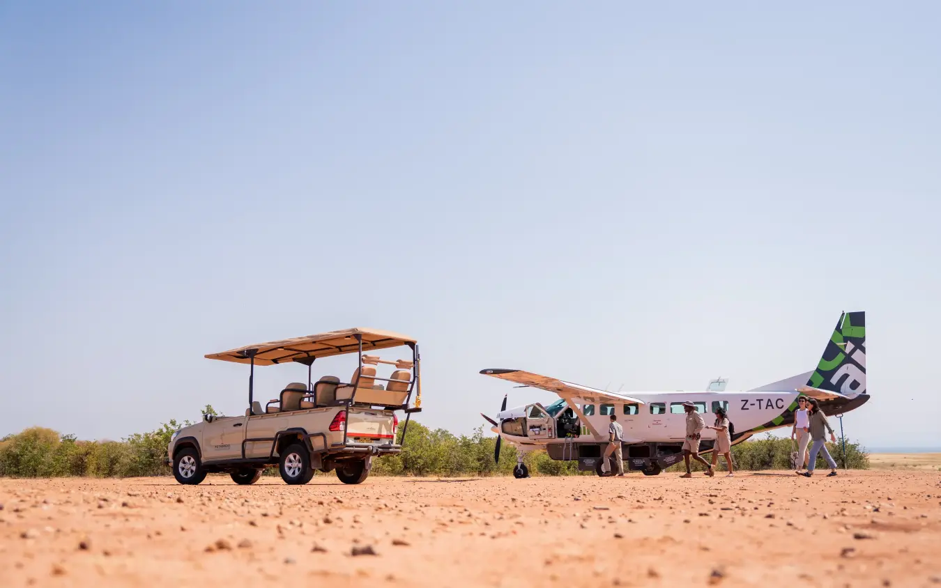 Small aircraft and safari vehicle parked on desert airstrip, Fothergill Island, Matusadona National Park, Zimbabwe