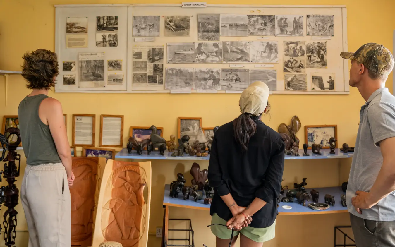 Museum interior with visitors viewing historical photographs and wooden sculptures, Fothergill Island, Matusadona National Park, Zimbabwe