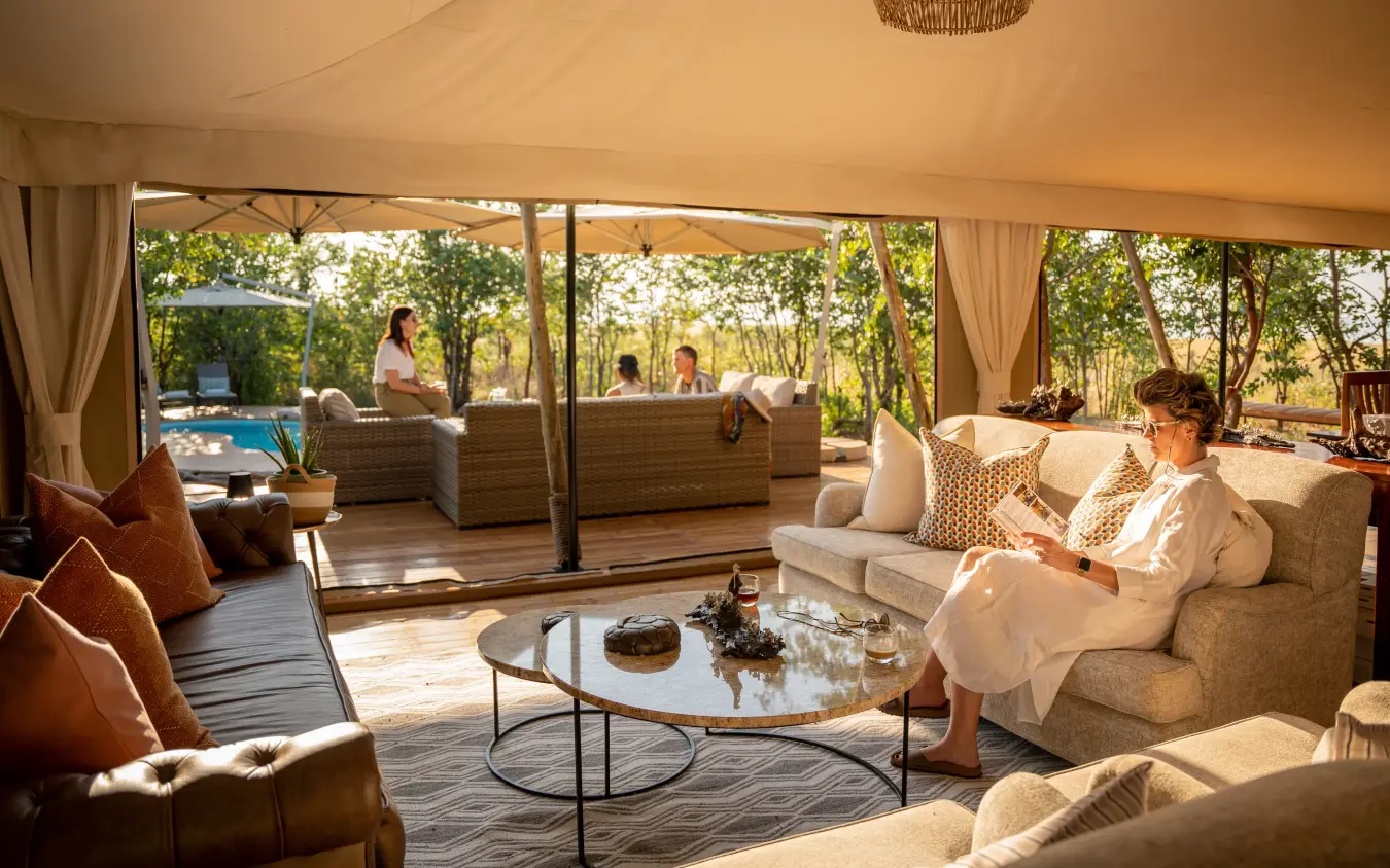 Luxury lounge pavilion with guests overlooking poolside garden landscape, Fothergill Island, Matusadona National Park, Zimbabwe