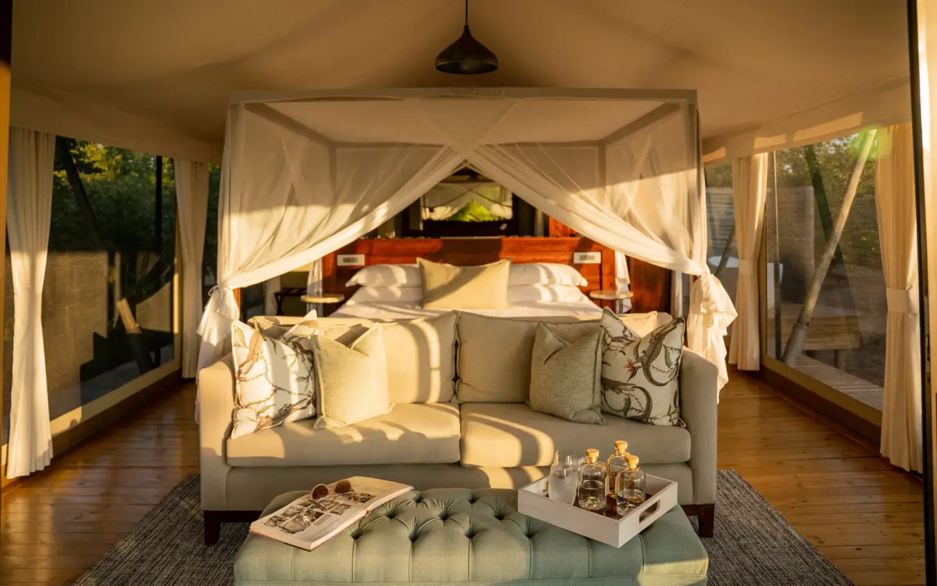 Luxury safari suite with canopy bed and lounge area overlooking woodland, Fothergill Island, Matusadona National Park, Zimbabwe